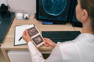 Back view of professional doctor radiologist analyzing scan MRI images in medical center photo