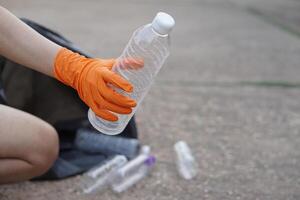Closeup hand wear gloves, hold plastic bottle. Concept, garbage management, reused, recycled plastic bottles. Keep clean and community service for the best environment. Zero waste. photo