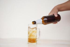 Close up hand hold bottle of beer to pour in glass. Concept, time for celebrate with cool favorite drink in party or relaxation after work. Drink for health or fun but don't drink for drunk. Beverage photo