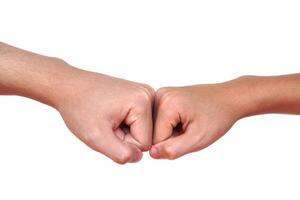 Close up two hands bump their fists together for greeting. Concept, Body language. Hands gesture symbol for greeting, giving respect or approval as companionship between two people. photo