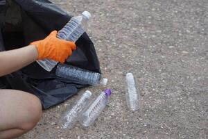 Closeup hand wear gloves, hold plastic bottle. Concept, garbage management, reused, recycled plastic bottles. Keep clean and community service for the best environment. Zero waste. photo
