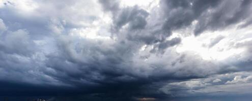 The dark sky with heavy clouds converging and a violent storm before the rain.Bad or moody weather sky and environment. carbon dioxide emissions, greenhouse effect, global warming, climate change photo