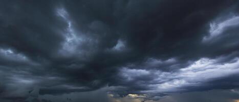 The dark sky with heavy clouds converging and a violent storm before the rain.Bad or moody weather sky and environment. carbon dioxide emissions, greenhouse effect, global warming, climate change photo