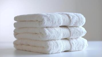 Stack of Fluffy White Towels on Light Neutral Background. photo