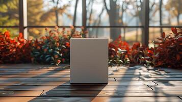 Minimalist White Box On Wooden Deck With Autumn Foliage Background Under Bright Morning Sunlight In Modern Garden Setting photo