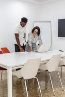 Two Colleagues Collaborating on a Laptop in a Modern Office Meeting Room photo