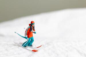 A miniature figurine of a skier dressed in vibrant winter gear. This image is perfect for themes related to winter sports photo