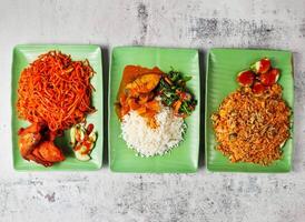 assorted singapore food mee goreng with chicken, nasi putih vegetable and ikan, nasi goreng ikan bilis served in dish isolated on grey background side view of singapore food photo