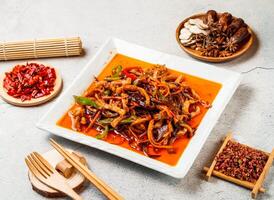 Fish flavored shredded pork with red chilli, chopsticks and fork served in pot isolated on background side view of taiwanese food photo