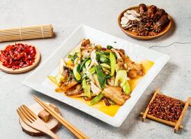 twice cooked pork with red chilli, chopsticks and fork served in pot isolated on background side view of taiwanese food photo
