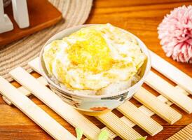 white rice with egg omelet served in dish isolated on wooden table side view of taiwan food photo