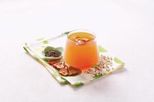 Hot Hawthorn Barley Detox Tea served in a mug isolated on napkin side view of hong kong food photo