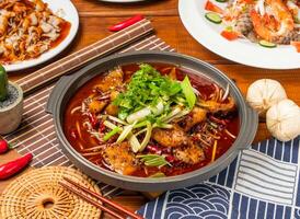 Chongqing Boiled Fish noodles with red chilli, spring onion coriander and chopsticks served in dish isolated on table side view taiwanese food photo