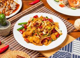 Kung Pao Chicken noodles with peanuts, spring onion red pepper and chopsticks served in dish isolated on table side view taiwanese food photo