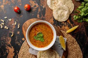 Madrooba or Madrouba soup with bread, lime and tomato cherry served in dish isolated on table top view of arabic breakfast photo