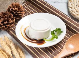 coconut pudding or Peanut tofu curd with wheat, spoon and fork served in dish isolated on napkin side view of taiwanese food photo