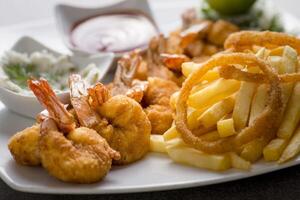shrimps bani or fried shrimp with fries and tomato sauce served in dish isolated on grey background top view of arabic food photo