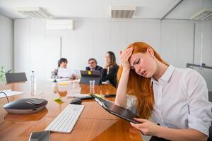 A stressed businesswoman at work touches her forehead, overload at work photo