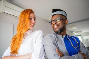 Two colleagues look at each other smiling in the office, happy business people of different cultures photo