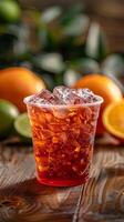 plastic cup of red tea with ice sits on a wooden table photo