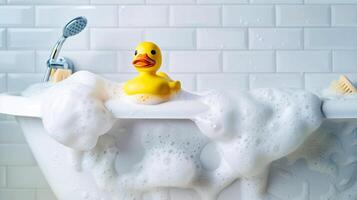 Rubber duck floating on white bathttub with soap foam photo