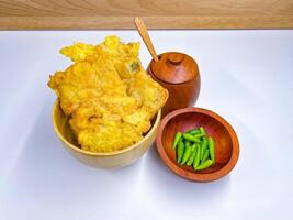 Traditional Indonesian Food Called Tempe Goreng or Mendoan or Fried Tempeh with Flour Batter served with Green Cayenne Pepper or Green Colored Chilli on Isolated White Background. High quality photo