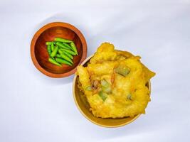 Traditional Indonesian Food Called Tempe Goreng or Mendoan or Fried Tempeh with Flour Batter served with Green Cayenne Pepper or Green Colored Chilli on Isolated White Background. High quality photo