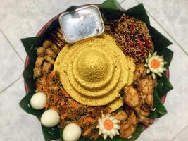a plate with tumpeng rice food on it in the shape of a pyramid photo
