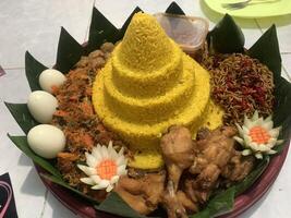 a plate with tumpeng rice food on it in the shape of a pyramid photo