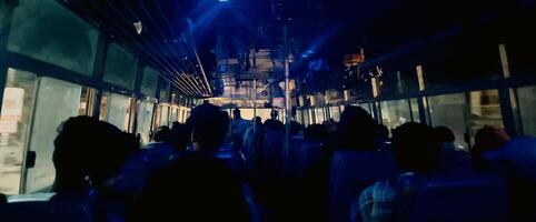 people sitting into the bus night time photo