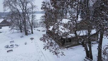 Cozy snow covered wooden house among snowy forest during snowfall video