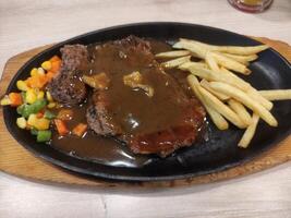 beef steak mixed with barbecue spices with fried potatoes and peanut carrot vegetables photo
