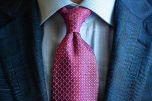 Close-Up of a Pink Patterned Tie With a Blue Suit photo