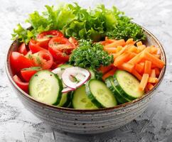 Fresco vegetal ensalada cuenco con pepino, tomate, y Zanahoria foto