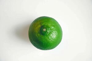 A Single Fresh Green Lemon on a White Background photo