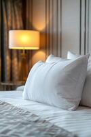 White Pillow on a Crisp Bed in a Hotel Room photo