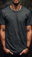 Man Wearing Grey T-Shirt and Leather Bracelet Posing Against Rough Wall photo