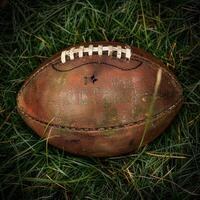 Worn Leather American Football Resting on Green Grass photo