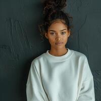 Stylish Black Woman in a White Sweatshirt Posing Against a Dark Background photo