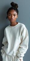 Stylish Black Woman In White Sweatshirt Posing Against A Solid Background photo