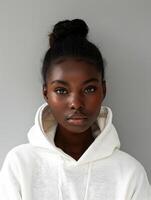 Stylish Black Woman in a White Sweatshirt Posing Against a Gray Background photo