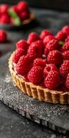 Raspberry Tart With Flaky Crust on Black Slate Serving Plate photo
