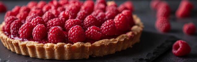 Fresh Raspberry Tart With Flaky Crust on Dark Surface photo