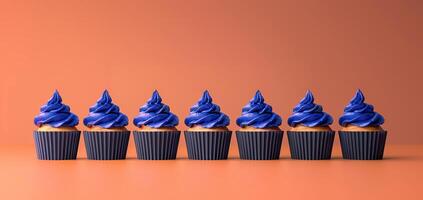 Modern design group black festive cupcakes lined row, smooth frosting simple orange purple colors photo