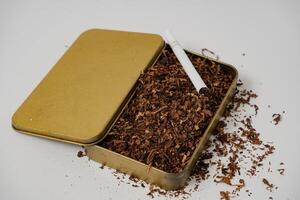 tobacco and some cigarettes around it with a white background photo