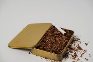 tobacco and some cigarettes around it with a white background photo