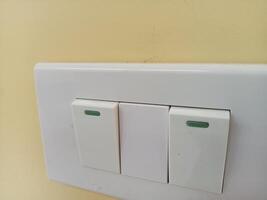 a white light switch with green buttons on it photo