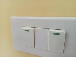 a white light switch with green buttons on it photo