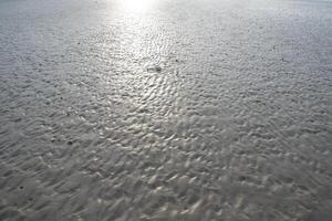 a person walking on a beach with a surfboard photo