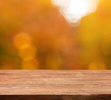 Wooden table top with blurred autumn photo